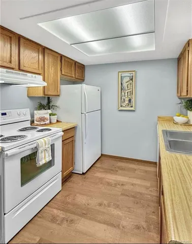 a kitchen with a stove a refrigerator and a sink
