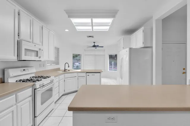 a kitchen with stainless steel appliances a white cabinets and stove top oven