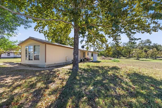 a view of a house with backyard and tree