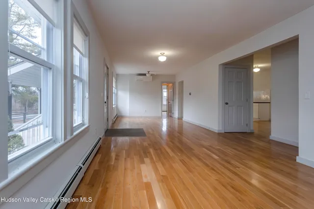 a big room with wooden floor and a fireplace