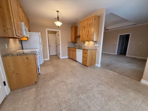 a view of a kitchen with furniture and a refrigerator