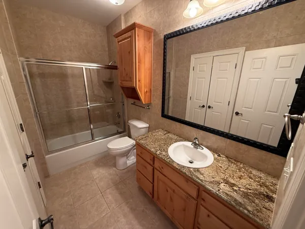 a bathroom with a granite countertop sink toilet and shower