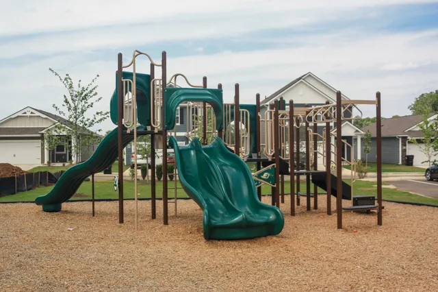 a view of a lake with a yard and large trees