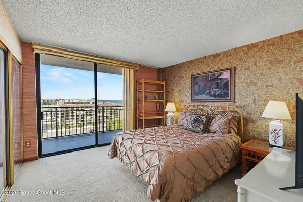 a bedroom with a bed and a large window