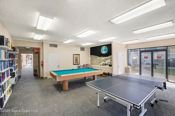 a room with pool table and windows
