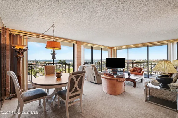 a dining room with furniture and a floor to ceiling window