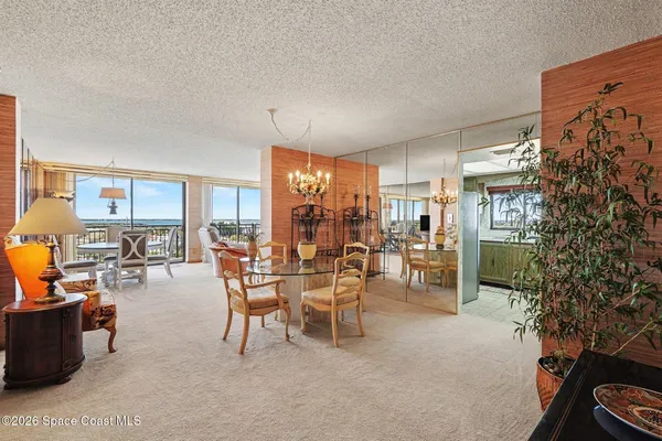a dining room with furniture and a potted plant