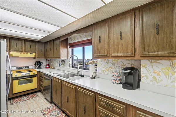 a kitchen with stainless steel appliances granite countertop a sink a stove and cabinets