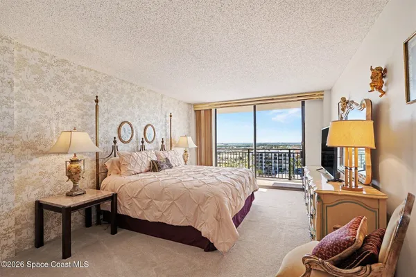 a bedroom with a bed and a large window