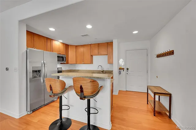 a kitchen with stainless steel appliances granite countertop a refrigerator and a stove top oven