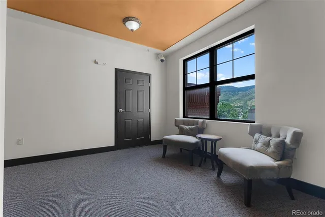 a view of a cafe with umbrellas in front of retail shops