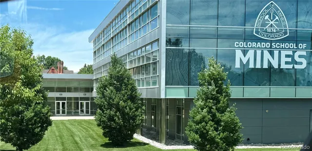 an aerial view of a city with lots of residential buildings and mountain view in back
