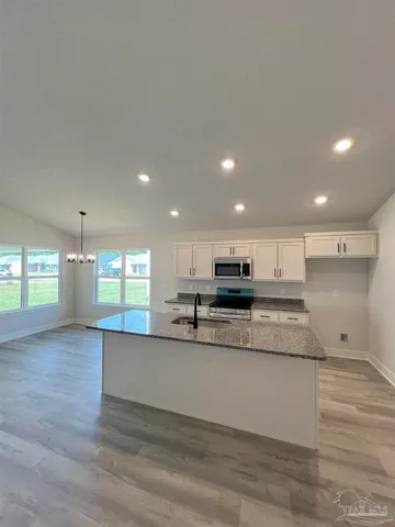a view of kitchen with kitchen island stainless steel appliances a sink and stove