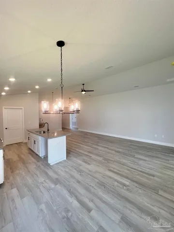 a large kitchen with kitchen island a stove a sink dishwasher and a wooden floor