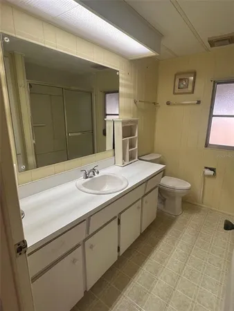 a bathroom with a double vanity sink mirror and toilet