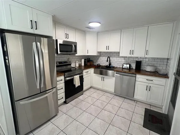 a kitchen with white cabinets stainless steel appliances and a sink