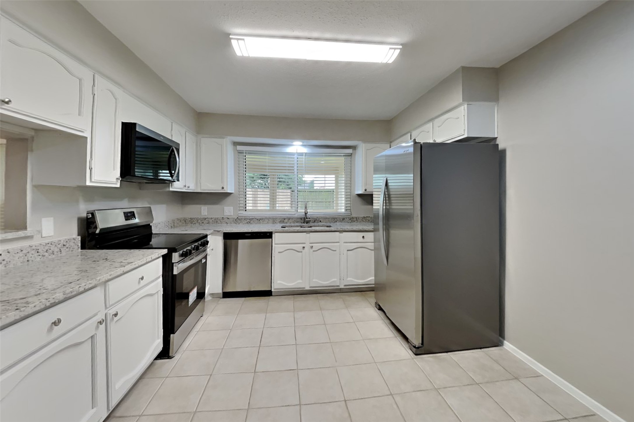 10015 Rippling Fields Drive Houston, TX 77064 - Photo 7 of 24 a kitchen with stainless steel appliances granite countertop a refrigerator and a stove top oven