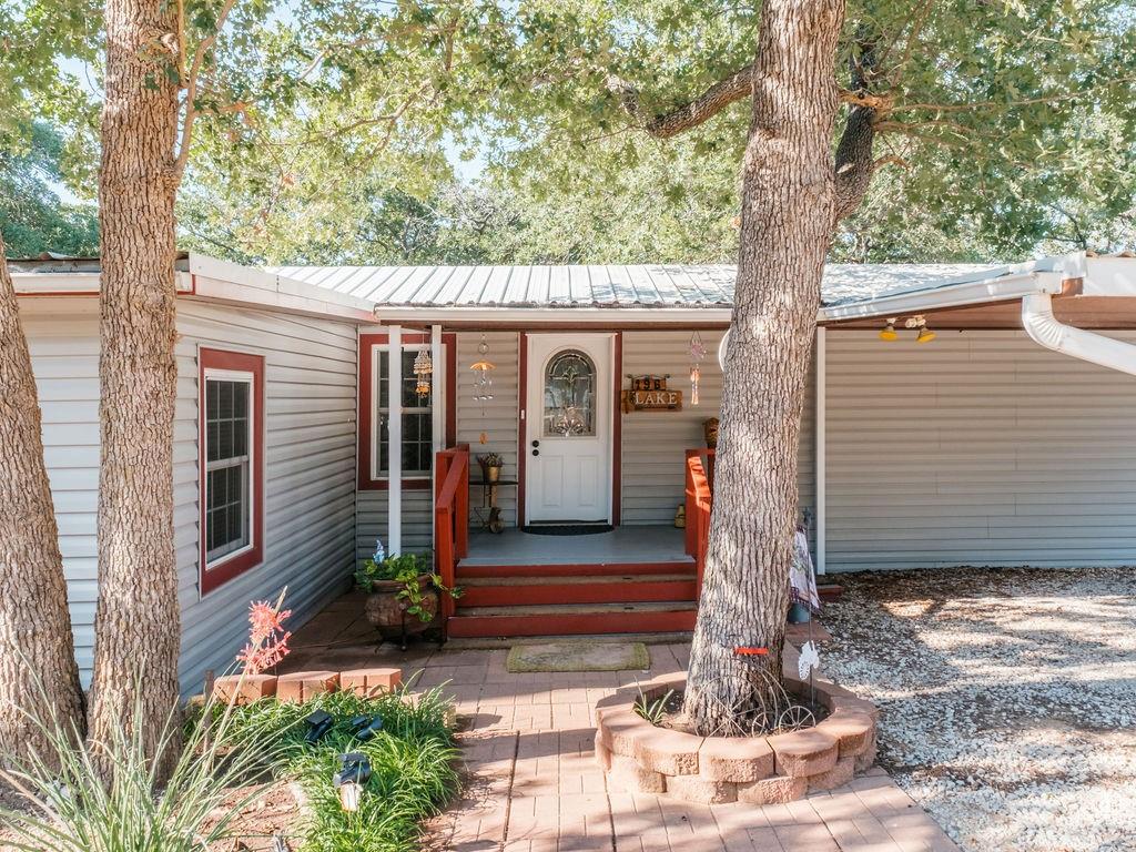 196 Perch Road Bowie, TX 76230 - Photo 2 of 33 a front view of a house with a tree