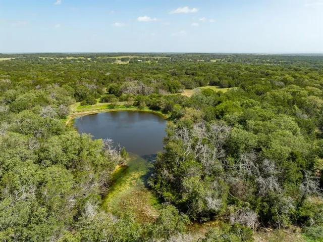 an aerial view of residential houses with outdoor space and trees