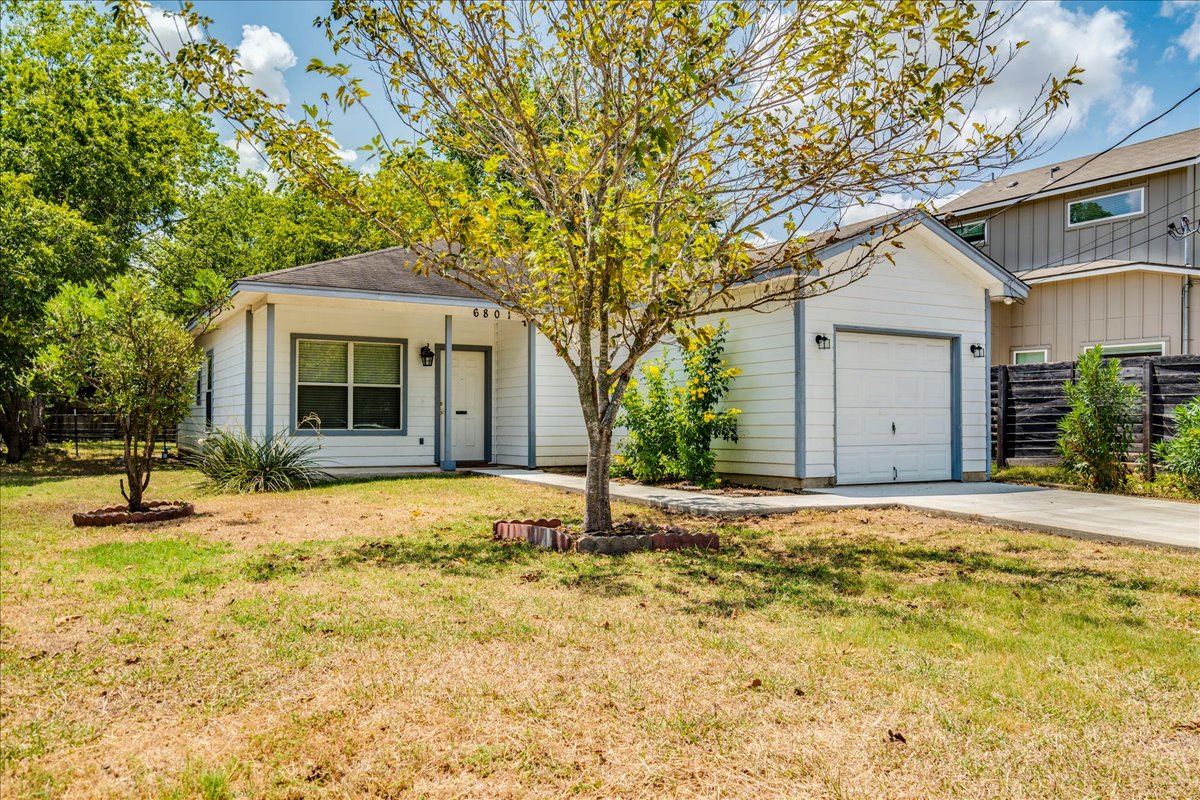 6801 Porter Street Austin, TX 78741 - Photo 28 of 30 A well-maintained facade with a single garage door and a tidy front yard creates a welcoming entrance.