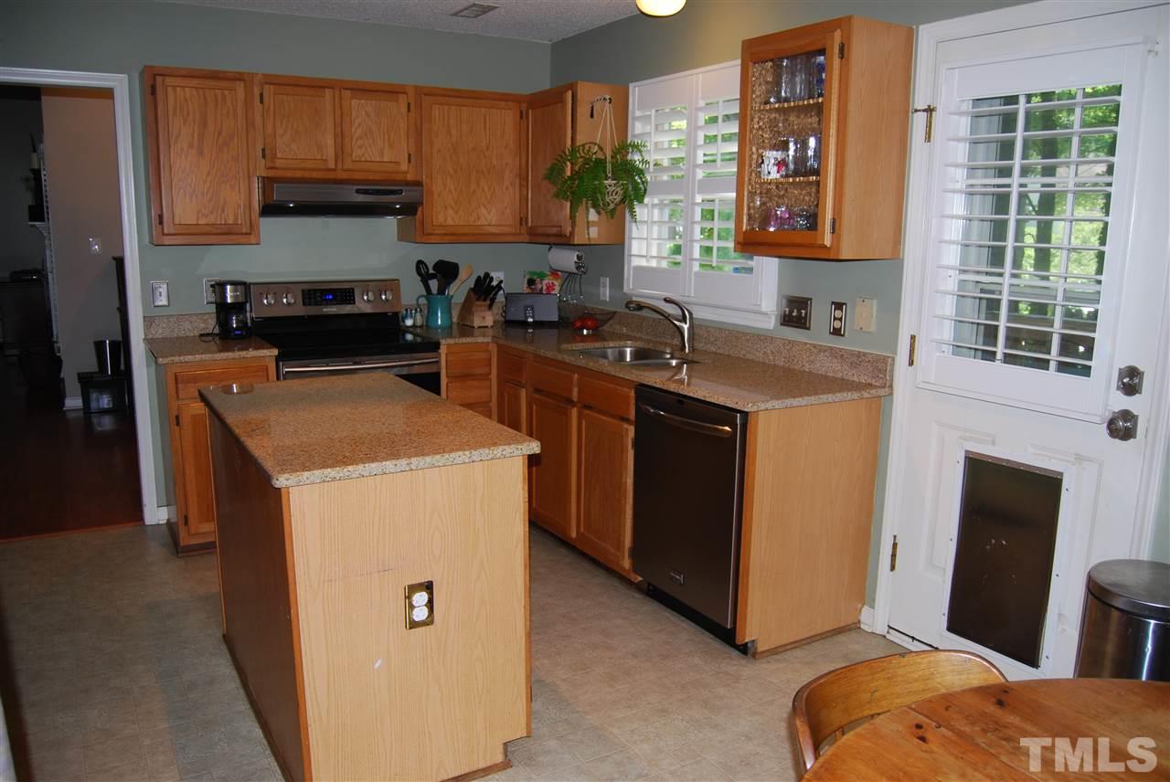 12301 Inglehurst Drive Raleigh, NC 27613 - Photo 12 of 23 a kitchen with stainless steel appliances granite countertop a stove a sink a refrigerator and a microwave