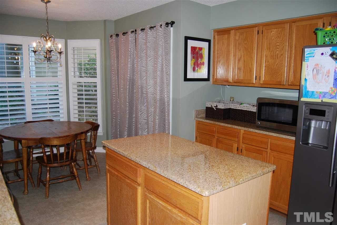 12301 Inglehurst Drive Raleigh, NC 27613 - Photo 13 of 23 a kitchen that has a cabinets and a table in it