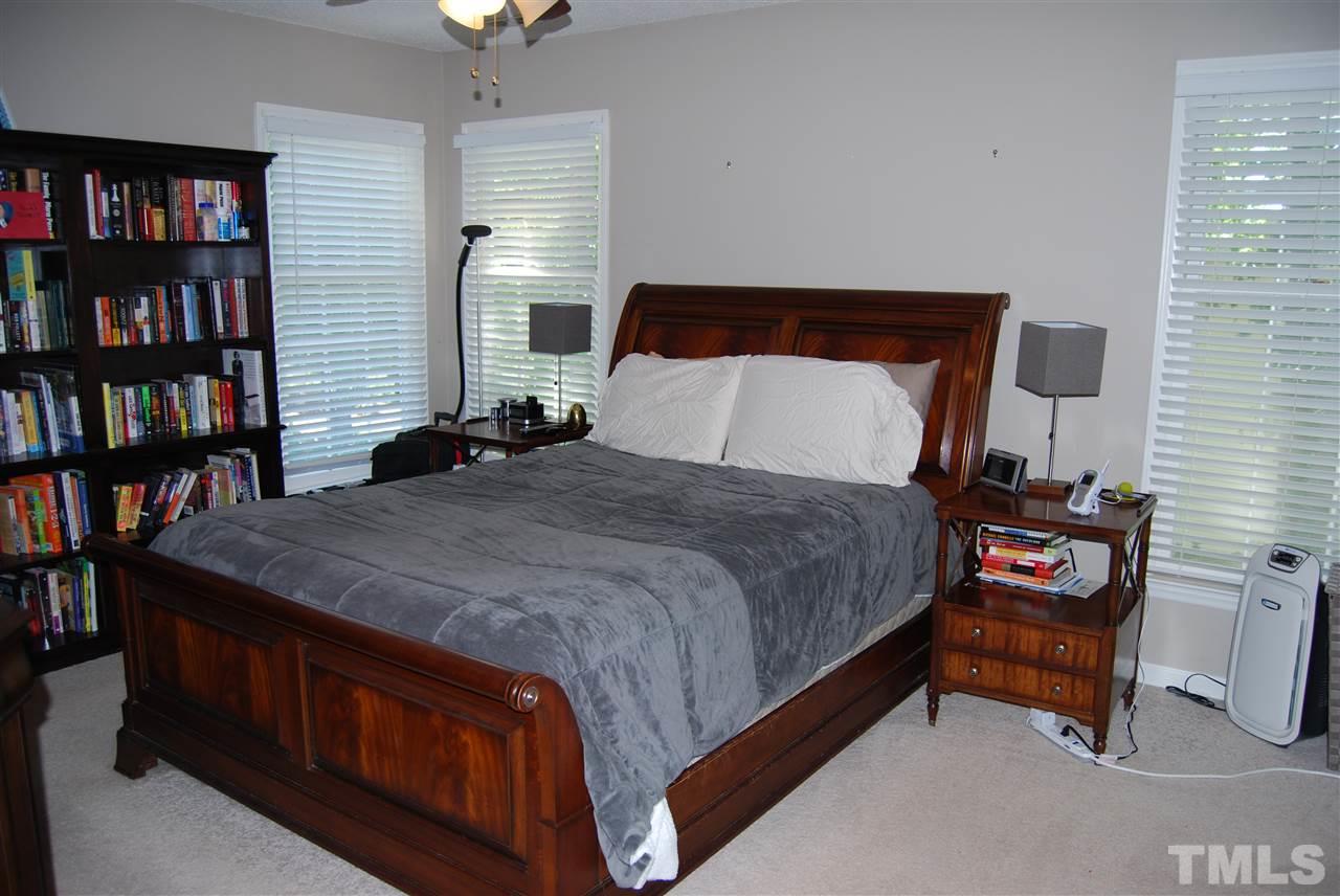12301 Inglehurst Drive Raleigh, NC 27613 - Photo 14 of 23 a bedroom with a bed a book shelf and a window