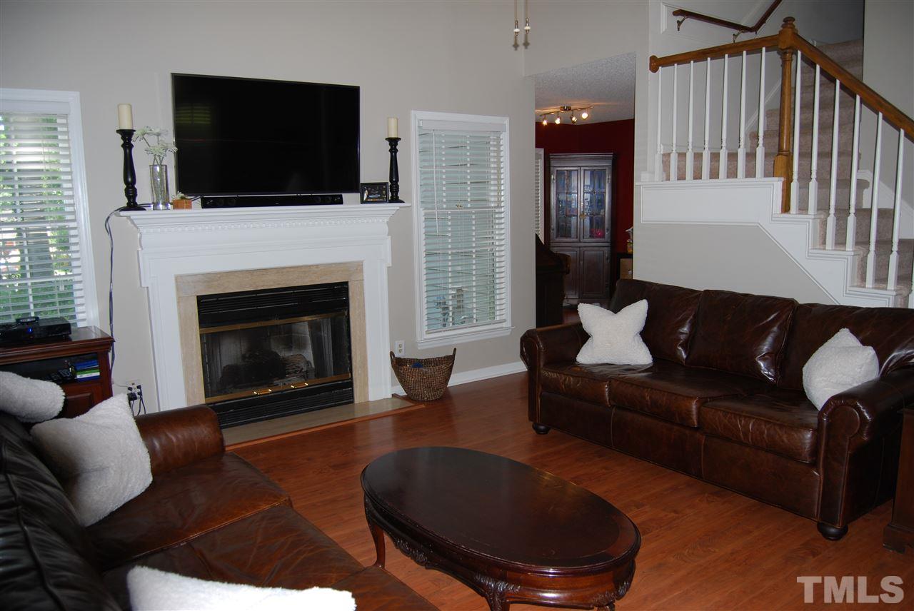12301 Inglehurst Drive Raleigh, NC 27613 - Photo 6 of 23 a living room with furniture a flat screen tv and a fireplace