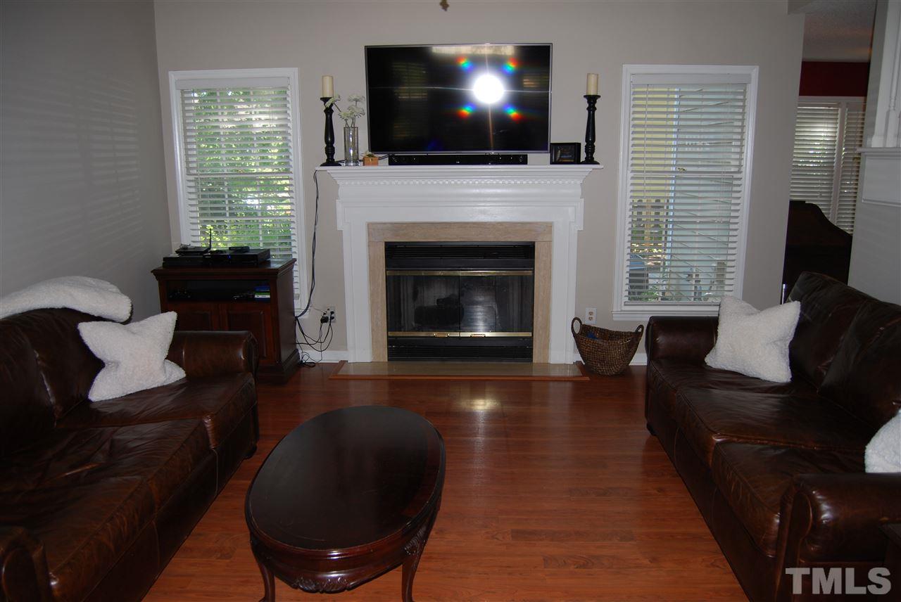12301 Inglehurst Drive Raleigh, NC 27613 - Photo 7 of 23 a living room with furniture a flat screen tv and a fireplace