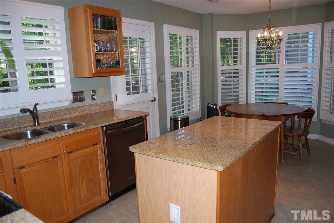 12301 Inglehurst Drive Raleigh, NC 27613 - Photo 10 of 23 a kitchen that has a sink and a table in it