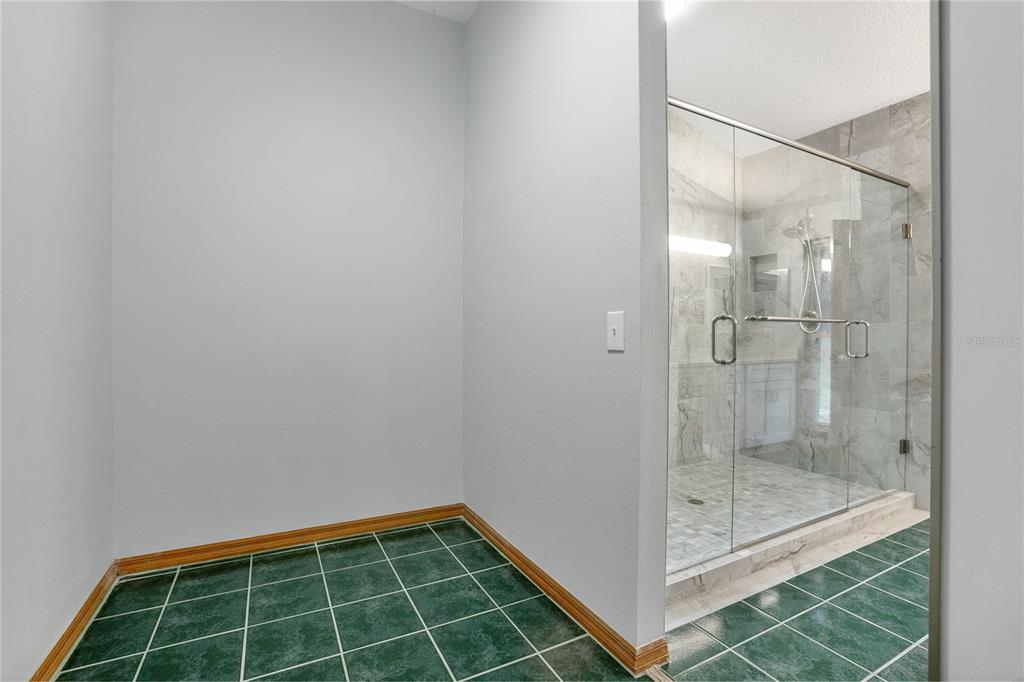 378 Glenwood Road DeLand, FL 32720 - Photo 17 of 38 a bathroom with a glass shower door