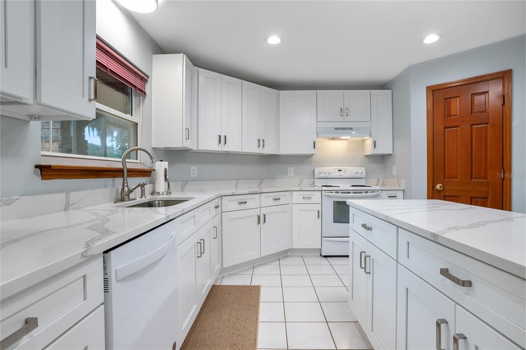 378 Glenwood Road DeLand, FL 32720 - Photo 7 of 38 a kitchen with granite countertop white cabinets and white appliances