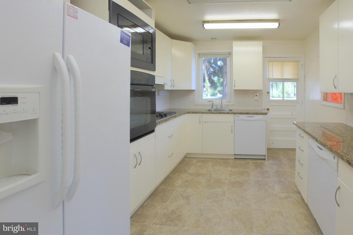 7514 Labyrinth Road Baltimore, MD 21208 - Photo 13 of 27 a kitchen with granite countertop a sink and white cabinets