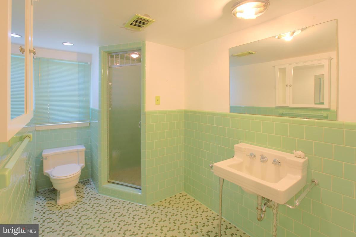 7514 Labyrinth Road Baltimore, MD 21208 - Photo 18 of 27 a bathroom with a sink toilet and shower