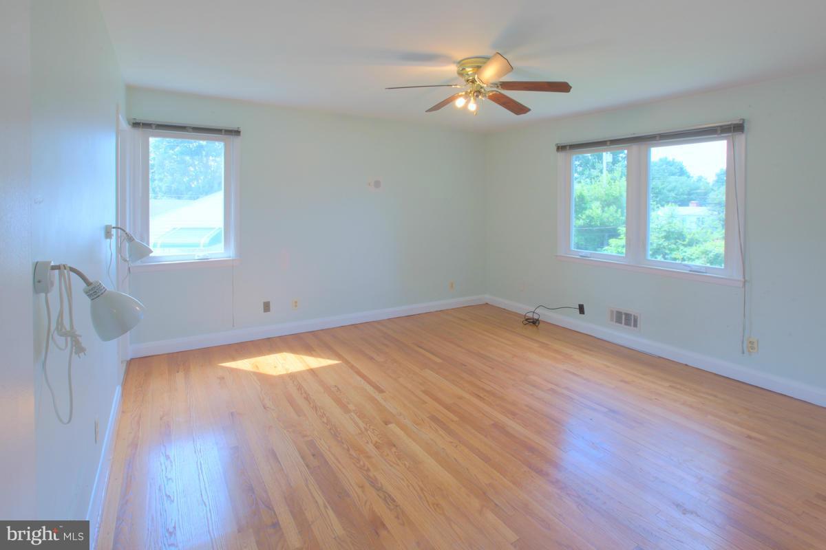 7514 Labyrinth Road Baltimore, MD 21208 - Photo 20 of 27 a view of empty room with wooden floor and fan