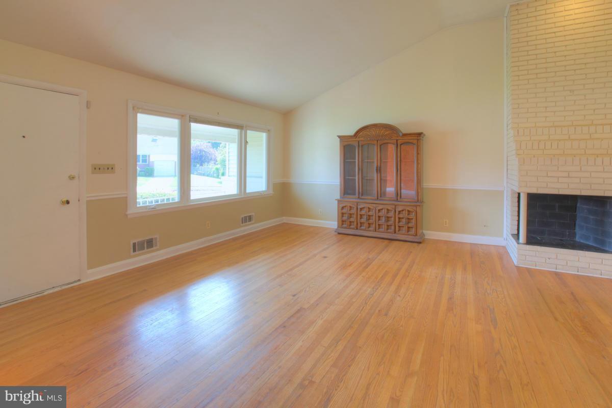 7514 Labyrinth Road Baltimore, MD 21208 - Photo 6 of 27 an empty room with wooden floor and windows
