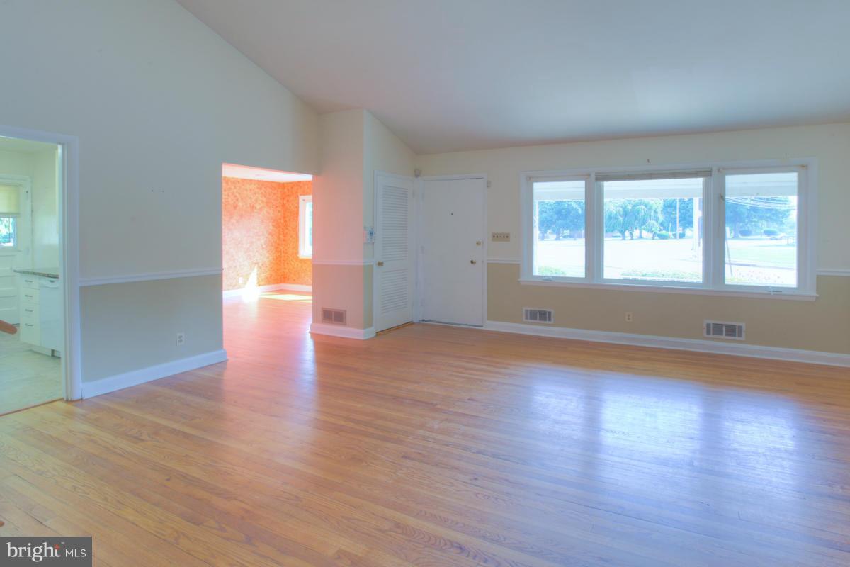 7514 Labyrinth Road Baltimore, MD 21208 - Photo 7 of 27 an empty room with wooden floor and windows