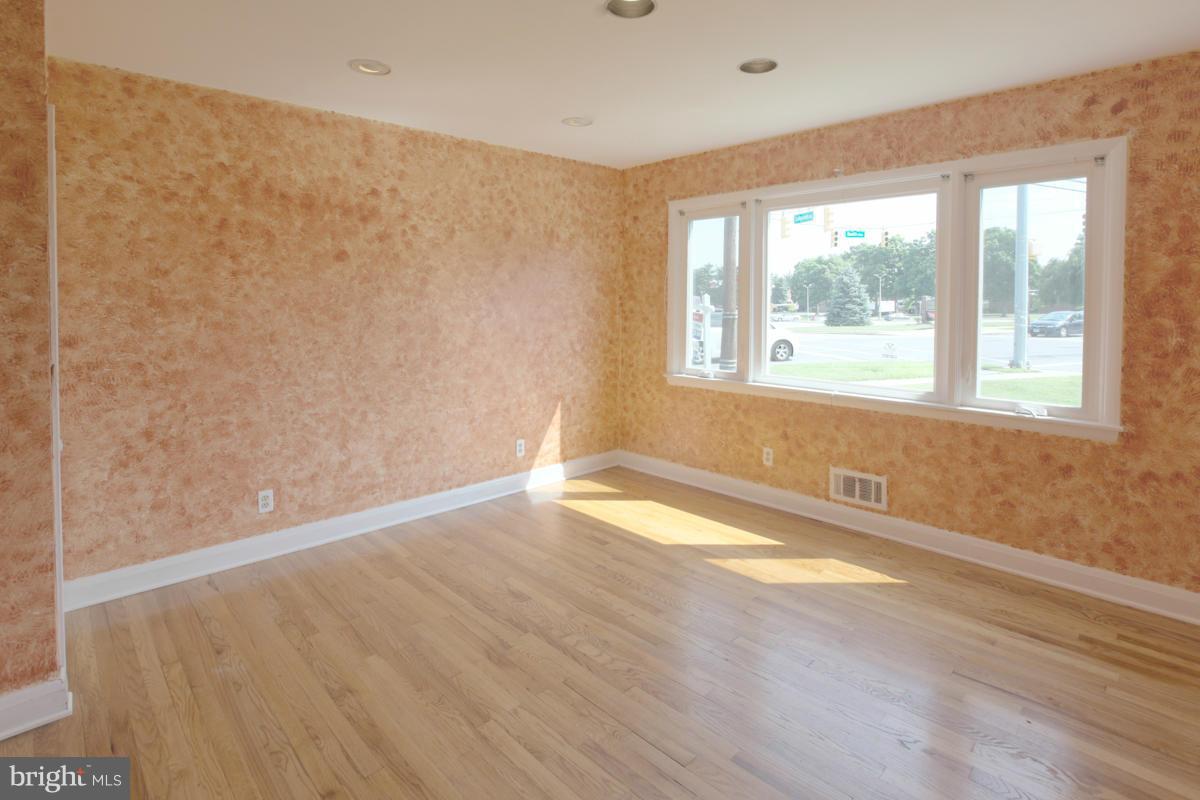 7514 Labyrinth Road Baltimore, MD 21208 - Photo 9 of 27 an empty room with wooden floor and windows