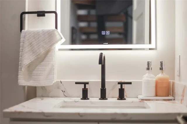 a bathroom with a granite countertop toilet sink and mirror