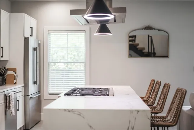a kitchen with a stove a sink a refrigerator and cabinets