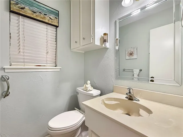 a bathroom with a sink toilet mirror and vanity