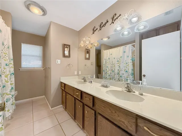 a spacious bathroom with a double vanity sink mirror and shower