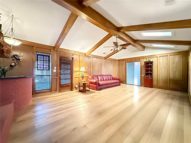 a view of a hall with wooden floor and a window