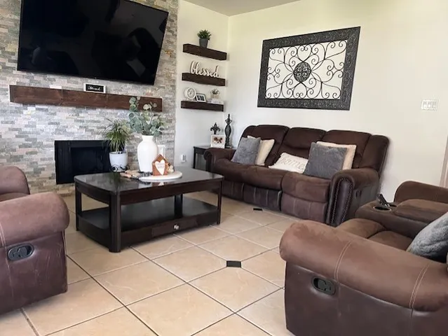 a living room with furniture a flat screen tv and a fireplace