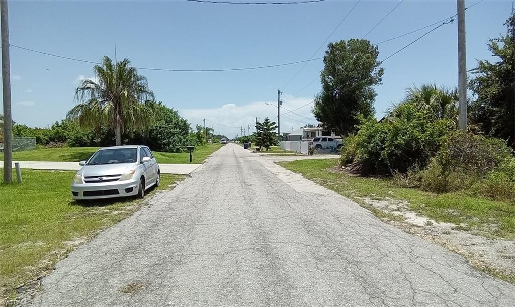 3123 26th Street Southwest Lehigh Acres, FL 33976 - Photo 4 of 5 a white house with a yard and a garden