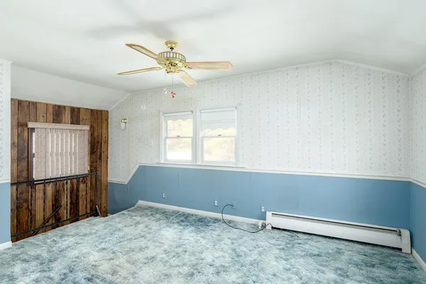 an empty room with windows and fan