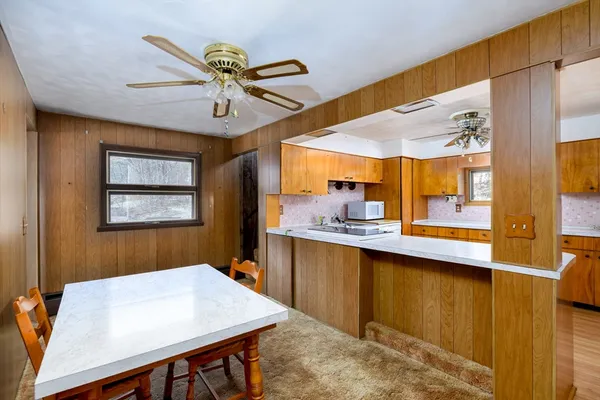 a dining room with stainless steel appliances wooden floor dining table and chairs