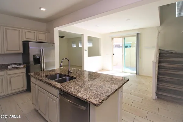 a kitchen with stainless steel appliances granite countertop a sink and a refrigerator