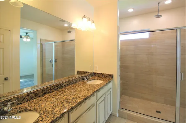 a bathroom with a granite countertop sink mirror and shower