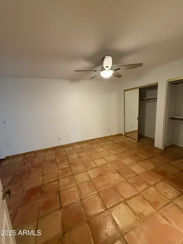 a view of an empty room and a chandelier fan